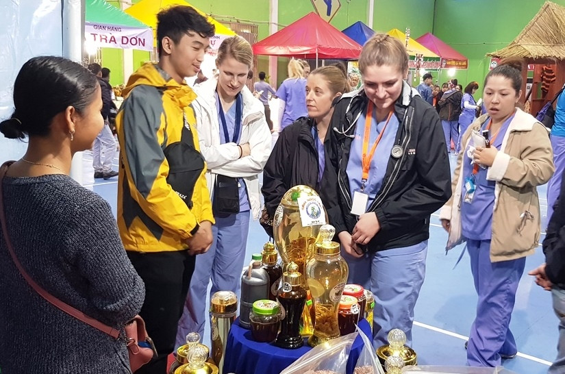 Du khách tìm hiểu về sâm Ngọc Linh tại phiên chợ sâm đầu năm. Ảnh: Hoàng Thọ