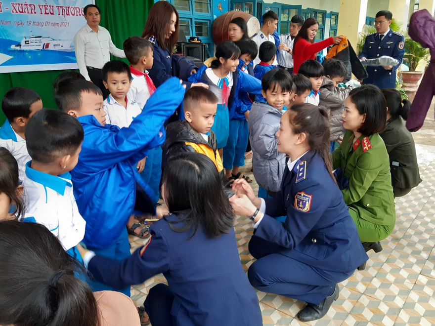 Các nữ chiến sĩ Vùng cảnh sát biển 2 trao áo ấm và quà cho học sinh có hoàn cảnh khó khăn, là con em của đồng bào dân tộc Cor. 