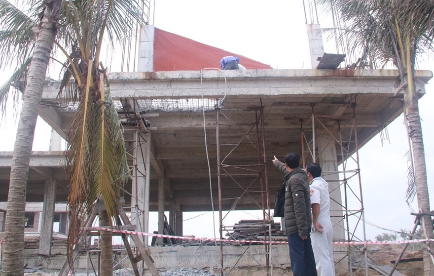 Lực lượng chức năng quận Ngũ Hành Sơn giám sát việc tháo dỡ các hạng mục vi phạm chỉ giới xây dựng. Ảnh : Nguyễn Thành