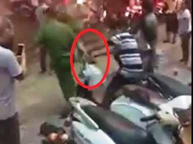 Người đàn ông mặc sắc phục công an nắm tóc người phụ nữ bán hàng rong