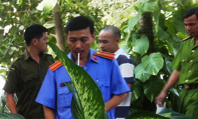 Lê Sơn Tùng (đầu trọc) đang dựng lại hiện trường vụ cướp tại nhà bà Trần Hồng Sa. 