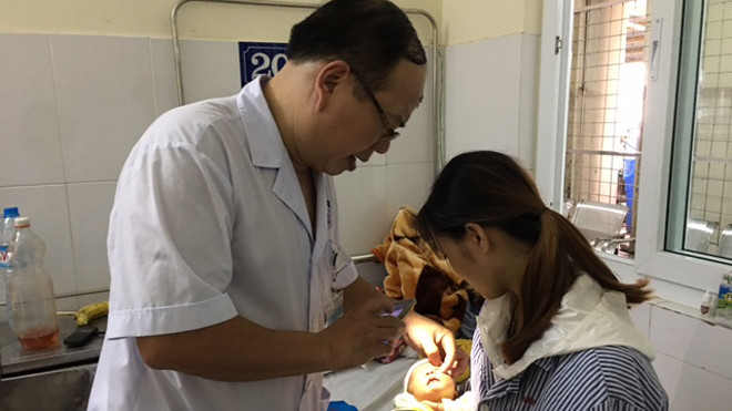 Bác sĩ Hoàng Cương khám mắt cho cháu Đinh Phương Thảo. Ảnh: Đỗ Hợp