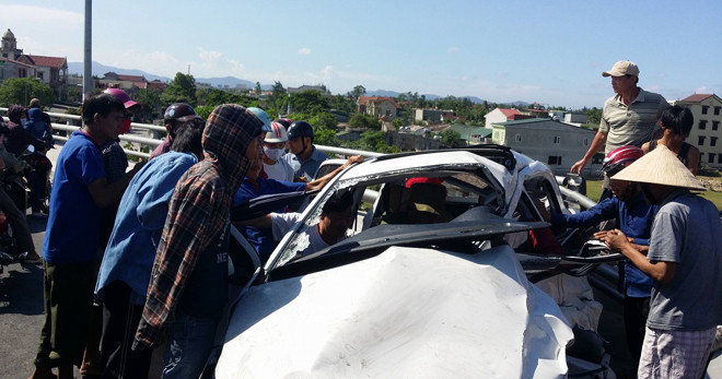 Người dân dùng xà beng để giải cứu tài xế ra khỏi cabin bẹp rúm.