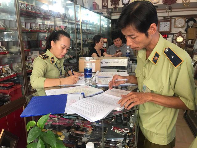 Lực lượng quản lý thị trường làm việc tại một cửa hàng 