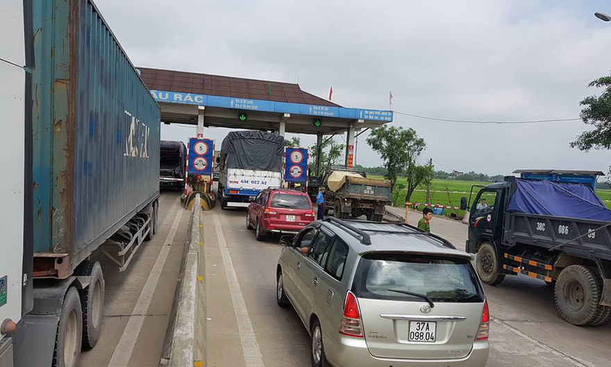 Người dân dùng xe dán logo dàn hàng phản đối việc thu phí tại Trạm thu phí cầu Rác.