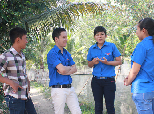 Nguyễn Lê Ngọc Chinh (thứ hai từ phải sang) chia sẻ kinh nghiệm làm mô hình “vườn - ao - hồ” khép kín với các bạn trẻ - Ảnh: Giang Phương