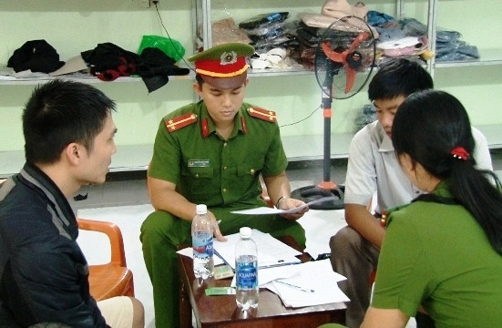 Công an lập biên bản về hành vi bán hàng không rõ nguồn gốc xuất xứ và gắn nhãn mác trái quy định. Ảnh: Phong Anh