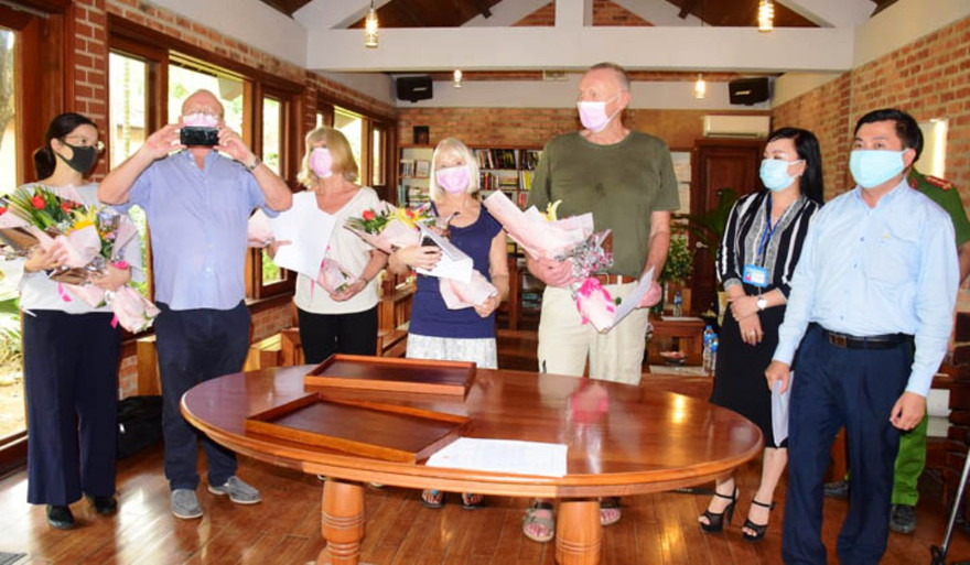 Du khách nhận hoa chức mừng, cùng chứng nhận hoàn thành cách ly 14 ngày và "tâm thư" của Chủ tịch tỉnh TT-Huế nhân mùa dịch Covid-19.