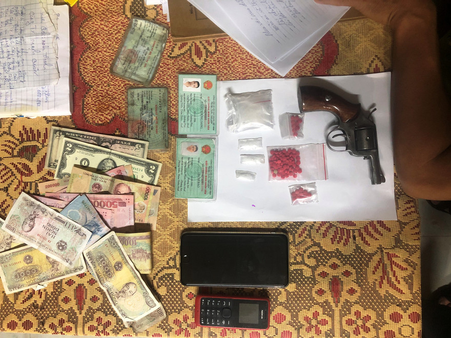 Tang vật súng ru-lô, ma túy, tiền, đô-la thu giữ từ đối tượng ma túy.