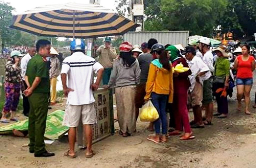 Thi thể nạn nhân T. được người dân vớt từ sông An Cựu lên bờ. Ảnh: A.Fong