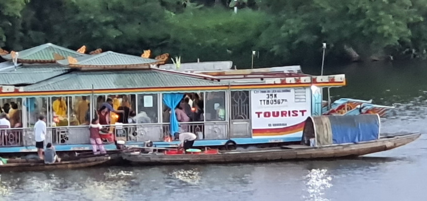 Hành vi rải vàng mã từ thuyền rồng xuống sông Hương bị người dân ghi lại.