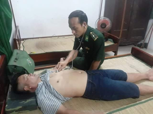 Kiểm tra sức khỏe ngư dân bị đắm thuyền sau khi được bộ đội biên phòng và dân địa phương đưa vào bờ an toàn