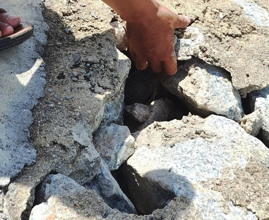 Đê ngăn lũ tại Quảng Vinh xây bằng đá hộc, chỉ cần dùng tay không có thể bóc gỡ từng mảng bê tông ra khỏi các phiến đá.