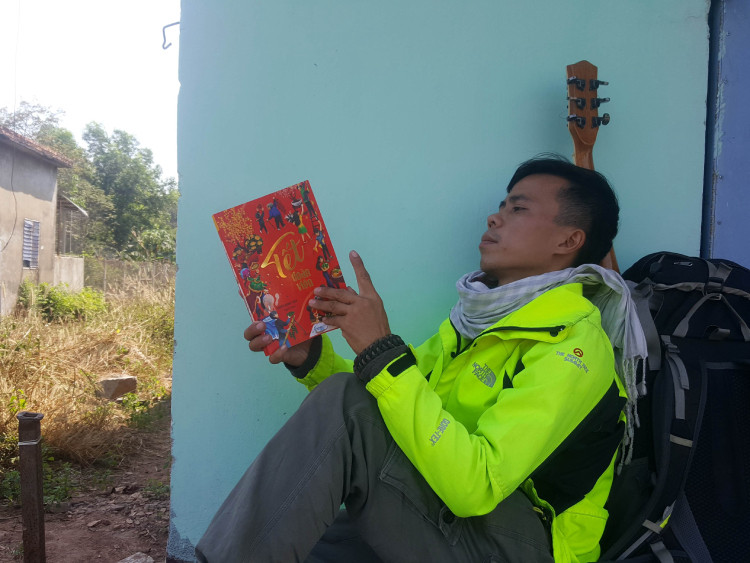 Hồ Nhật Hà trong ngôi nhà bỏ không tình cờ gặp ở Bình Phước, với hành trang là sách, đàn ghi ta, bên cạnh một ba lô các thứ thiết yếu. Ảnh: Nhân vật cung cấp.