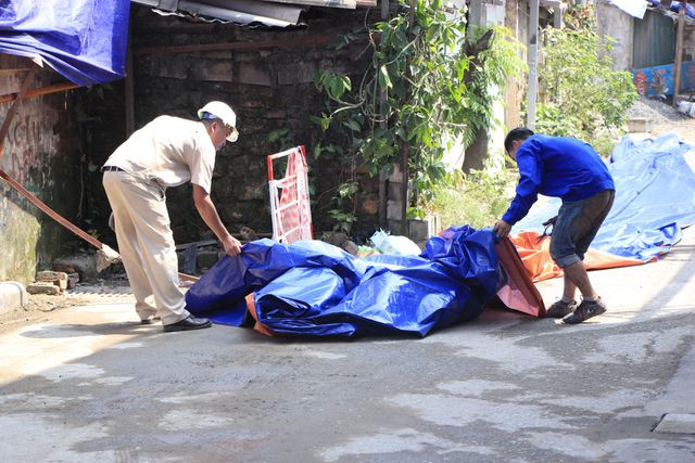 Sáng ngày 6/9, nhiều công nhân tiếp tục việc quây bạt xung quanh khu vực giáp ranh giữa nhà máy và khu dân cư tại ngõ 342, đường Hạ Đình, phường Hạ Đình, quận Thanh Xuân, Hà Nội. (Ảnh: Trần Thanh).