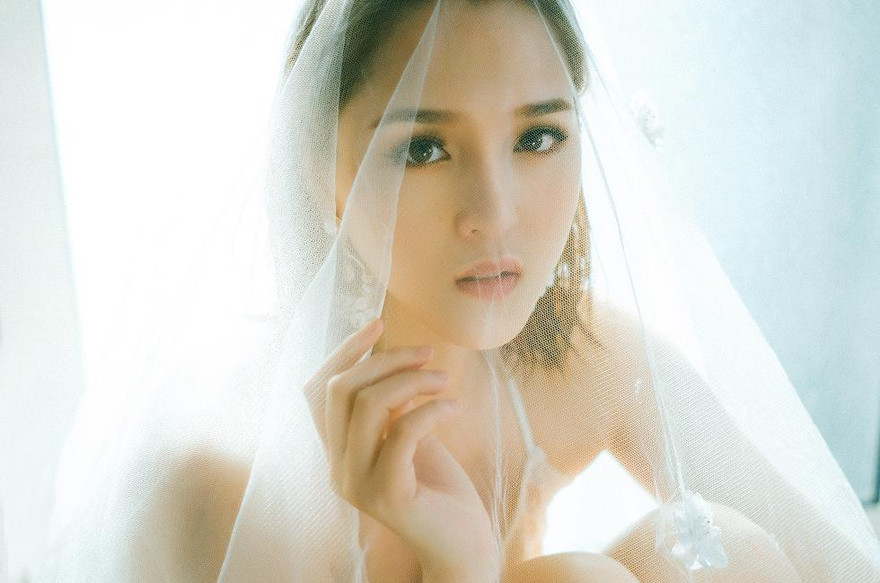 Á hậu Hoàng Anh hóa thân thành cô dâu kiêu kỳ với váy cưới và khăn voan trắng muốt.