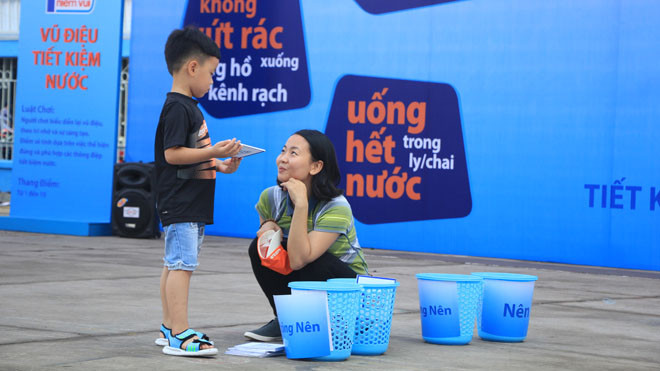Người dân tham gia trò chơi nhắc nhở ý thực tiết kiệm nước sạch trong khuôn khổ ngày hội diễn ra từ 8 đến 17 giờ.
