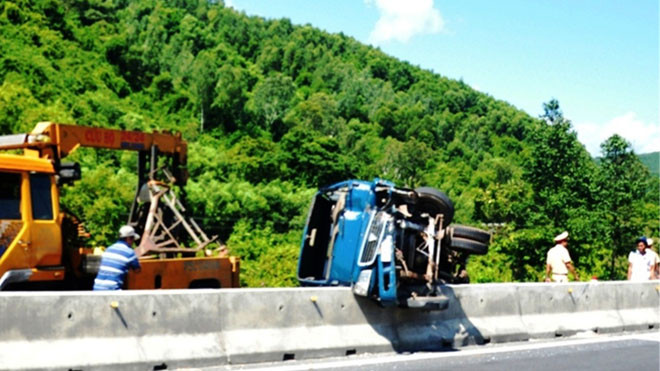 Xe tải nằm vắt ngang lơ lửng trên dải phân cách bê tông của Quốc lộ 1A sau khi gặp nạn