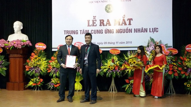 Ông Phạm Văn Cường, Phó giám đốc Học viện trao quyết định bổ nhiệm giám đốc trung tâm cho ông Vũ Ngọc Huyên (người cầm quyết định)