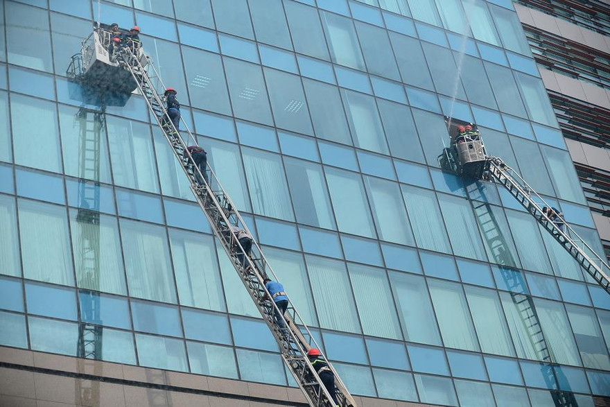 Lực lượng PCCC đang hướng dẫn người dân thoát nạn bằng xe thang chuyên nghiệp.