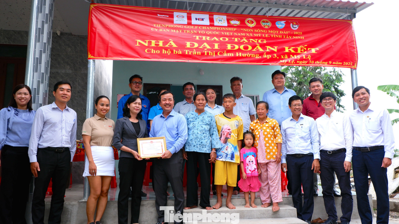 Các đại biểu chụp ảnh lưu niệm tại lễ trao tặng nhà "Đại Đoàn kết" cho hộ bà Trần Thị Cẩm Hường ( xã Mỹ Lệ). Ảnh: Hữu Huy