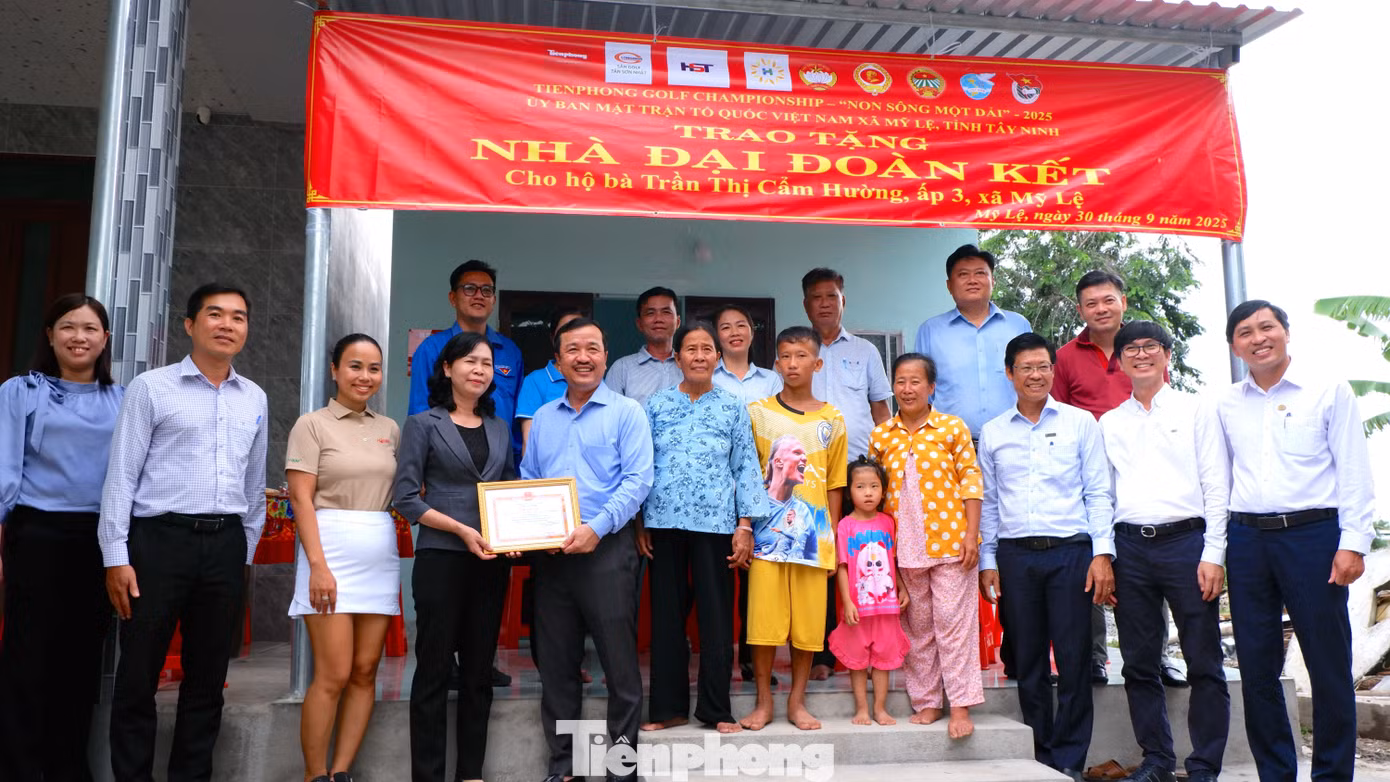 Các đại biểu chụp ảnh lưu niệm tại lễ trao tặng nhà "Đại Đoàn kết" cho hộ bà Trần Thị Cẩm Hường ( xã Mỹ Lệ). Ảnh: Hữu Huy
