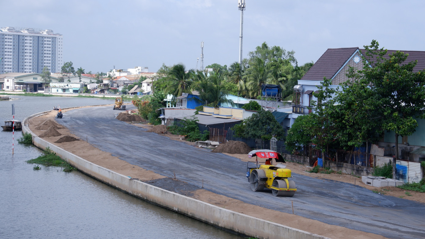 Đoạn cuối tuyến kênh ở gần khu vực rạch Nước Lên, công nhân và máy móc đang thi công thảm nhựa đường. tham-luong-7.jpg