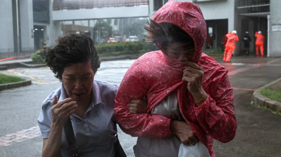 Một số người đi trong gió mạnh ở Hong Kong (Trung Quốc) khi bão Wipha đến gần vào ngày 20/7 (bão không đổ bộ Hong Kong). Ảnh: Tyrone Siu/ Reuters. hkwipha.jpg