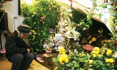 Tiến sĩ Nguyễn Thái Tự bên khu non bộ mô phỏng động Phong Nha - Kẻ Bàng dưới chân cầu thang