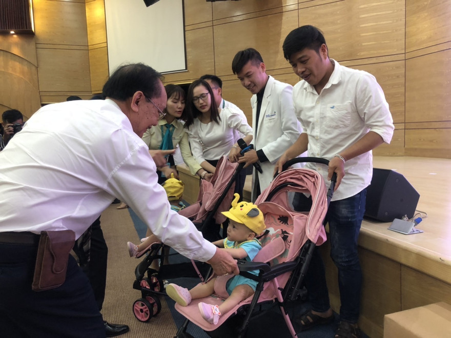 GS Trần Đông A nắm tay song Nhi trước khi bé xuất viện