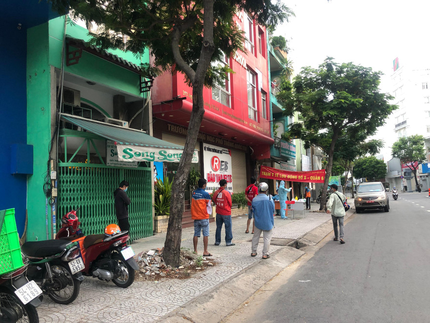 Shipper xếp hàng xét nghiệm COVID-19 tại một điểm y tế lưu động ở quận 6