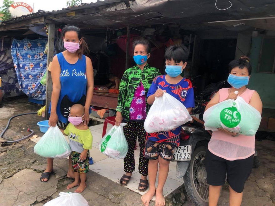 Chị Trần Thị Thu Trúc (bìa trái) vui mừng vì nhận được phần thực phẩm thiết yếu