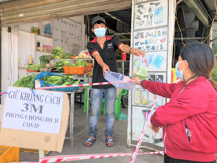 Người dân đứng giãn cách khi mua hàng (ảnh: H.C)