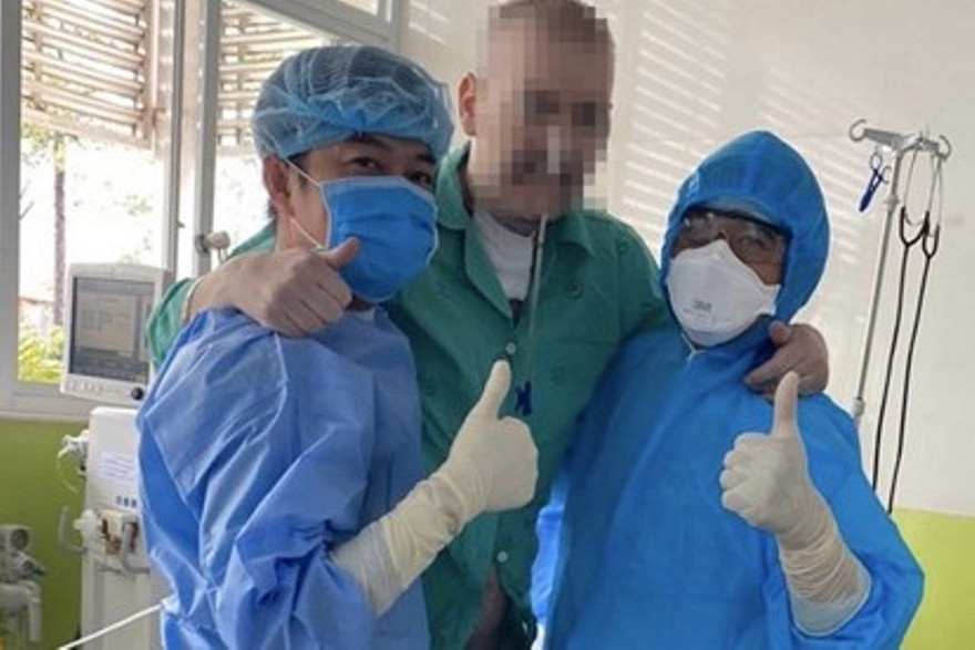 Bệnh nhân 91 tập đi với sự hỗ trợ của nhân viên y tế (ảnh: Lê Nguyễn)