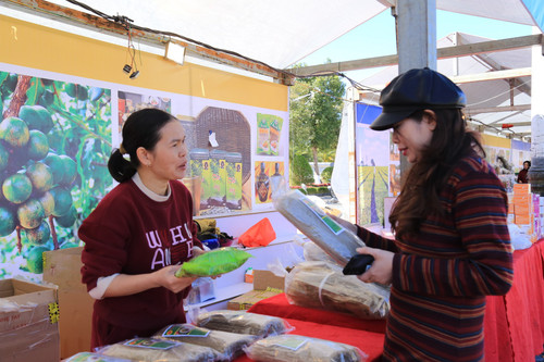 Chị Bùi Thị Hồng Thu bán hàng cho khách tại hội chợ trong tuần Du lịch - Văn hóa Lai Châu 2025.