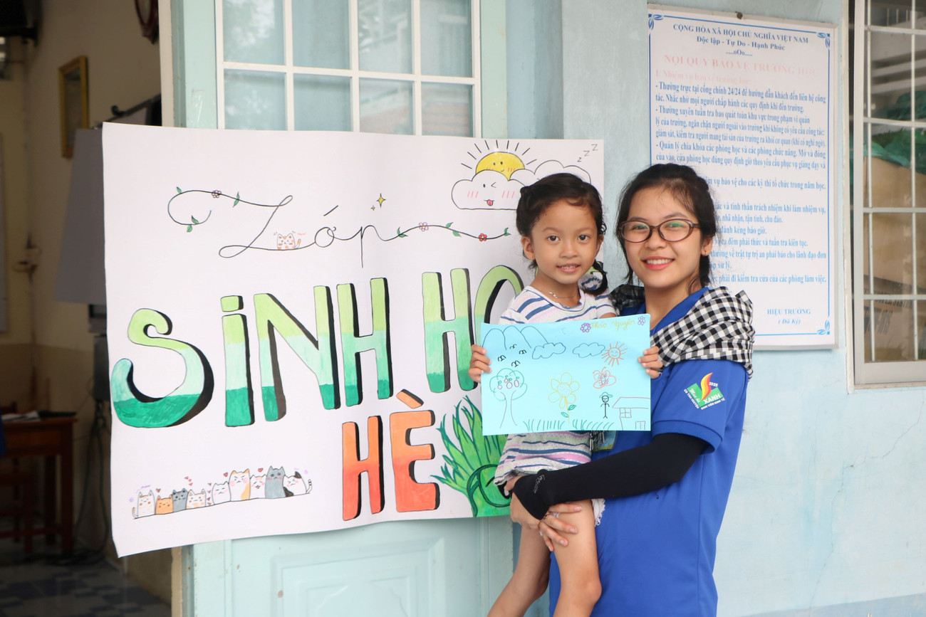 Nữ chiến sĩ tình nguyện tươi cười bên cạnh em nhỏ tại Vĩnh Long. anh-13.jpg