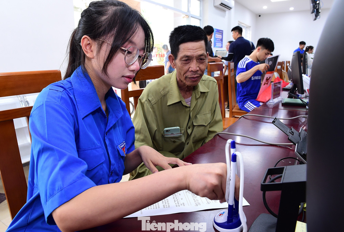 Tình nguyện viên Lê Xuân Mai hỗ trợ người dân tại Trung tâm phục vụ hành chính công xã. Ảnh: Xuân Tùng tp-tangqua-tinhnguyen-laocai9.jpg