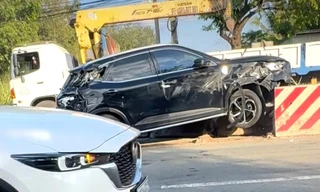 Xế hộp 'ủi' dải phân cách sau va chạm với xe đầu kéo container ở TPHCM 