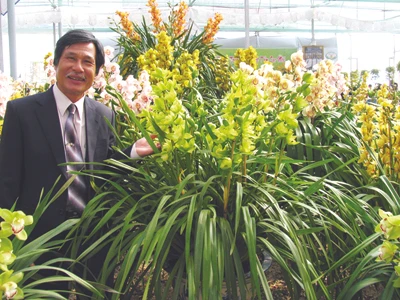 Nghệ nhân Đoàn Văn Quỳnh bên sản phẩm hoa lan của mình. Ảnh: Kim Anh