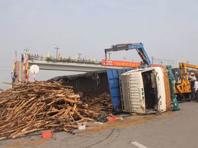 Giải cứu tài xế khi xe chở gỗ bị lật