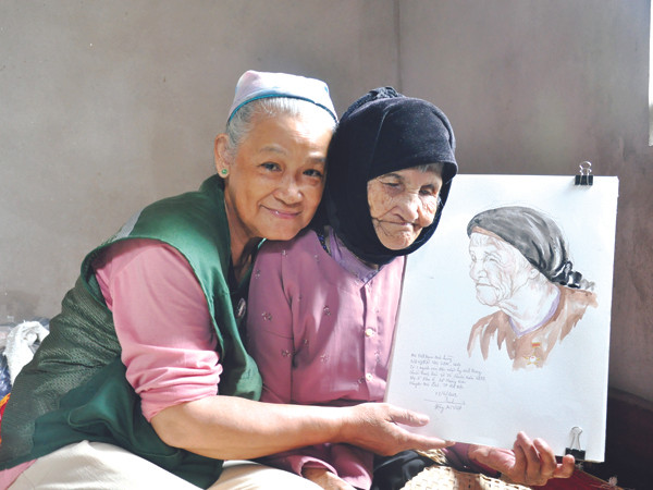 Họa sĩ Đặng Ái Việt cùng nguyên mẫu và tác phẩm (Mẹ Nguyễn Thị Lan ở Mê Linh, Hà Nội) Ảnh: NVCC