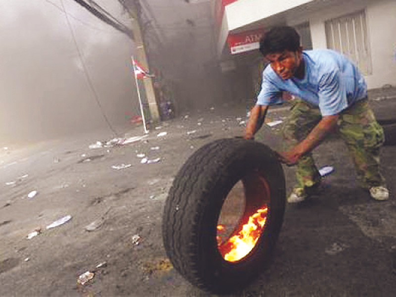 Một người biểu tình đốt lốp xe ngăn binh lính