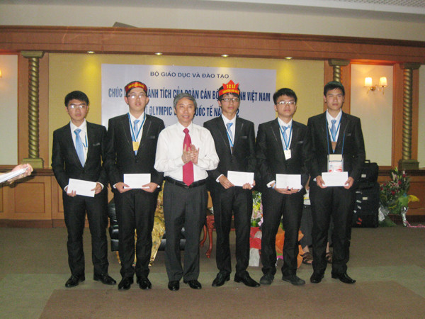 Đội tuyển học sinh Việt Nam dự IPho 2012 ở Estonia và ông Ngô Kim Khôi, Cục trưởng Cục Khảo thí & Kiểm định Chất lượng Giáo dục, Bộ GD&ĐT tại sân bay Nội Bài. Long đứng bên phải ông Khôi, Hải đứng bên trái Ảnh: Quý Hiên