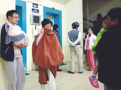 Vợ chồng trẻ bế đứa con 10 ngày tuổi chạy động đất ở chung cư CT3C ở khu đô thị Bắc Linh Đàm Ảnh: T.L