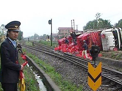 Ô tô chở bia lật sát đường tàu