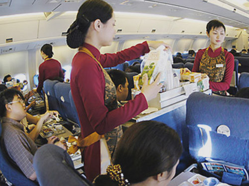 Nữ tiếp viên VNA đang phục vụ hành khách trên máy bay - Ảnh minh hoạ