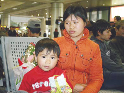 Chị Đào Thị Duyên cùng con nhỏ chờ đón chồng tại sân bay Nội Bài