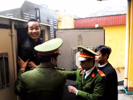 Đặng Trần Hoài tươi cười khi bước ra khỏi xe thùng tại sân tòa