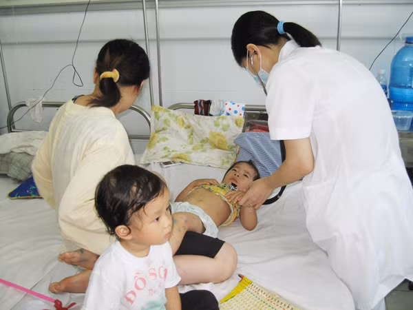 Bác sĩ khám cho bệnh nhi mắc TCM tại BV Nhi T.Ư. Ảnh:T.Hà