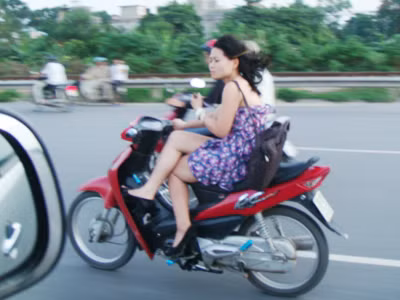 Thiếu nữ vắt chân chữ ngũ... đi xe máy